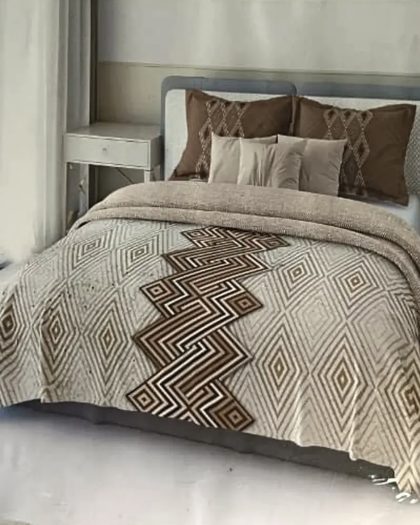 Elegant beige and brown geometric patterned bedspread with matching decorative pillows