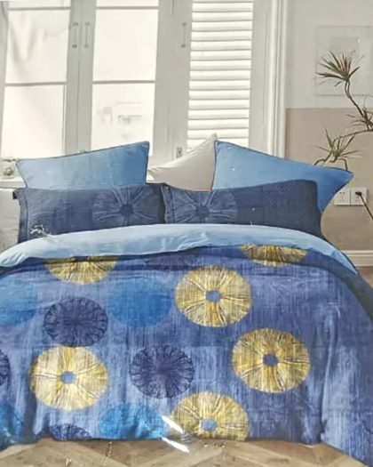 Blue bedspread with gold and navy circular floral patterns and matching decorative cushions
