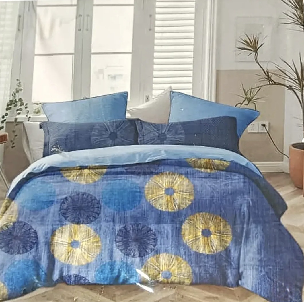 Blue bedspread with gold and navy circular floral patterns and matching decorative cushions